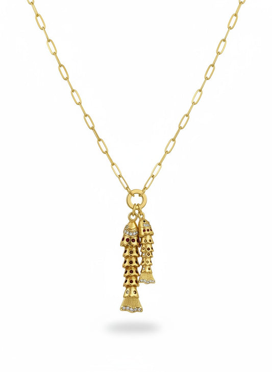 SHINY COLLECTION gold necklace with two dangling fish charms adorned with red stones and small diamonds.